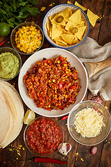 Image showing Mexican food concept. Vegetable burritos. Served on pan. Tortilla guacamole, salsa, chilli and beans