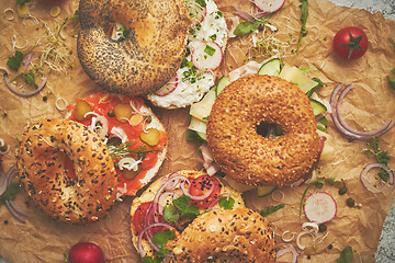 Image showing Tasty colorful various bagels with healthy ingredients served on brown baking paper