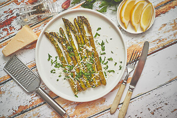 Image showing Delicious roasted asparagus served on white ceramic plate. With 