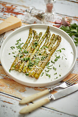 Image showing Roasted asparagus with parmesan cheese and parsley. Healthy spring food concept. View from above.