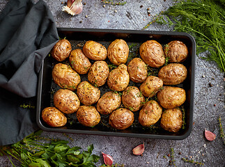 Image showing Tasty fresh homemade baked potatoes served on a metal tray. With