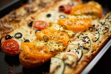 Image showing Long baguettes pizza sandwiches with tuna, mushrooms, tomatoes and cheese on a metal baking tray