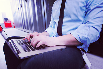 Image showing engineer working on a laptop in server room