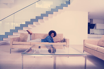 Image showing African American woman using laptop on sofa