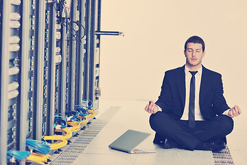 Image showing business man practice yoga at network server room