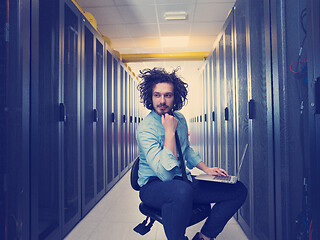 Image showing engineer working on a laptop in server room