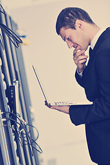 Image showing businessman with laptop in network server room