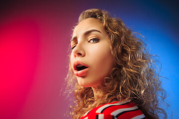 Image showing The serious sad woman standing and looking at camera against colorful background.