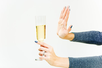 Image showing Hand of woman refusing glass with alcoholic beverage, on white background