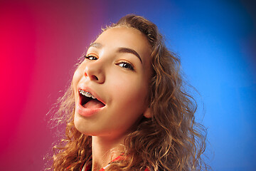 Image showing The happy business woman standing and smiling against red and blue background.