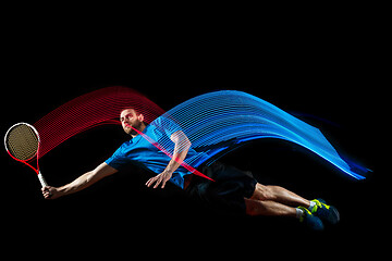 Image showing one caucasian man playing tennis player on black background