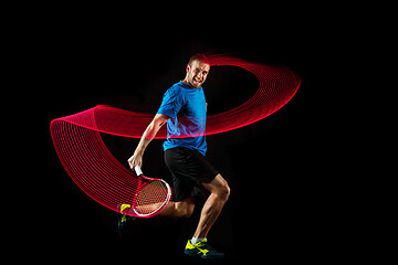 Image showing one caucasian man playing tennis player on black background