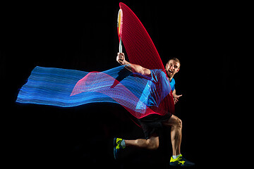 Image showing one caucasian man playing tennis player on black background