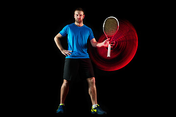 Image showing one caucasian man playing tennis player on black background