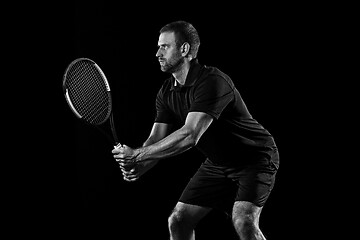 Image showing one caucasian man playing tennis player on black background