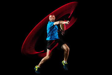 Image showing one caucasian man playing tennis player on black background