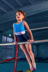 Image showing beautiful girl is engaged in sports gymnastics on a parallel bars