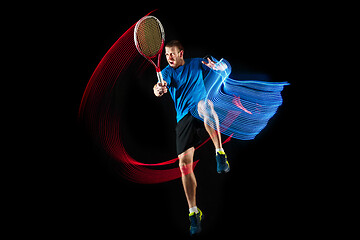 Image showing one caucasian man playing tennis player on black background