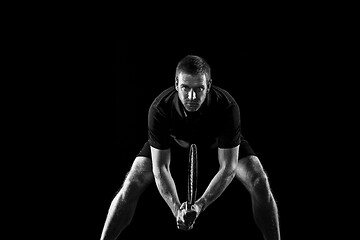 Image showing one caucasian man playing tennis player on black background