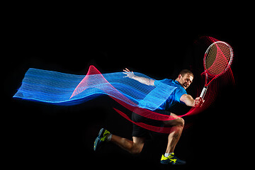 Image showing one caucasian man playing tennis player on black background