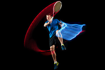 Image showing one caucasian man playing tennis player on black background