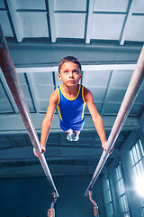 Image showing beautiful boy is engaged in sports gymnastics on a parallel bars