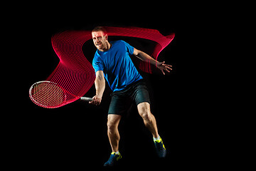 Image showing one caucasian man playing tennis player on black background