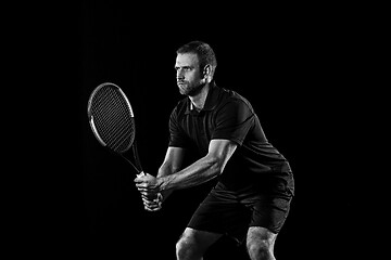 Image showing one caucasian man playing tennis player on black background