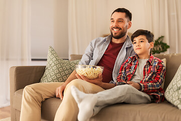 Image showing father and son with popcorn watching tv at home