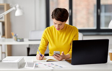 Image showing smiling ui designer using smartphone at office