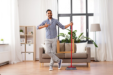 Image showing smiling indian man with broom cleaning at home