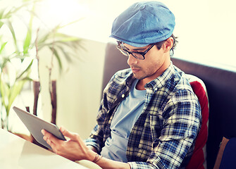 Image showing man with tablet pc sitting at cafe table