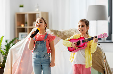 Image showing girls with guitar and microphone playing at home