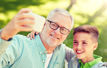 Image showing old man and boy taking selfie by smartphone