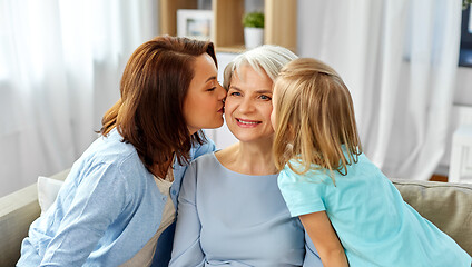 Image showing mother and daughter kissing happy grandmother