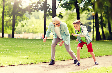 Image showing grandfather and grandson racing at summer park