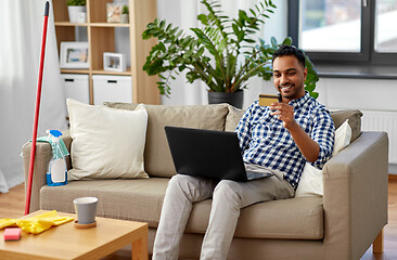 Image showing man with laptop shopping online after cleaning