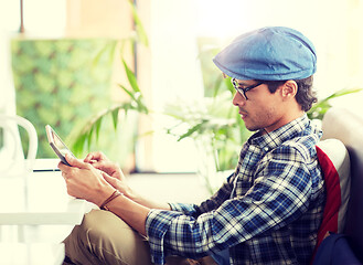 Image showing man with tablet pc sitting at cafe table