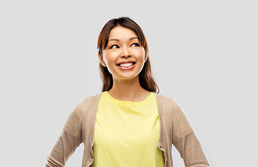 Image showing happy asian woman looking up over grey background