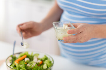 Image showing close up of pregnant woman cooking salad at home