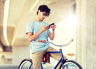 Image showing man with smartphone and earphones on bicycle