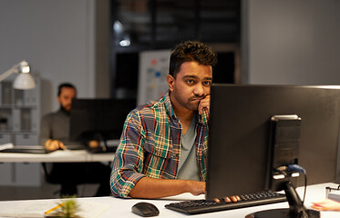 Image showing creative man with computer working at night office