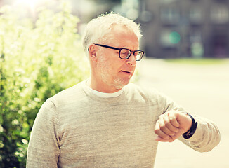 Image showing senior man checking time on his wristwatch