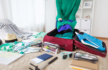 Image showing woman packing travel bag at home or hotel room