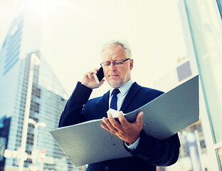 Image showing senior businessman calling on smartphone in city