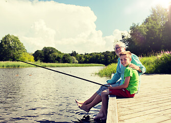 Image showing grandfather and grandson fishing on river berth