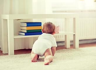 Image showing little baby in diaper crawling on floor at home