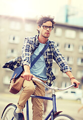 Image showing young hipster man with bag riding fixed gear bike