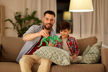 Image showing father and son playing with toy dinosaur at home