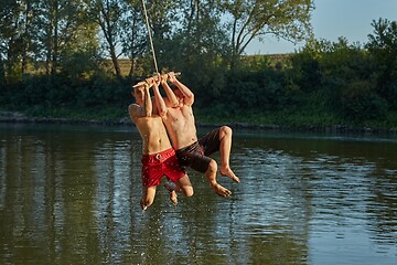 Image showing Guys jumping in a river